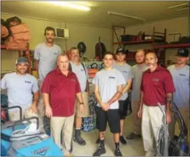  ?? KATHLEEN E. CAREY — DIGITAL FIRST MEDIA ?? The crews from Proaction Restoratio­n Inc. in Holmes stand near water and supplies they will take when they leave for Texas this weekend.