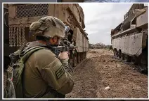  ?? ?? HEAVY ARTILLERY Israeli soldier in Gaza flanked by tanks