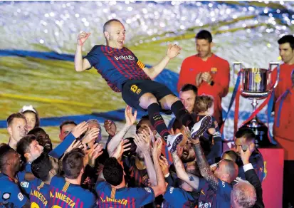  ??  ?? Barcelona midfielder Andres Iniesta and teammates celebrate after the La Liga match against Real Sociedad at the Nou Camp in Barcelona on Sunday. The hosts, which had already clinched the league title, won 1-0 to end the season as Iniesta ended his...