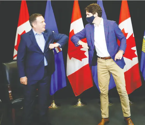  ?? JEFF MCINTOSH / THE CANADIAN PRESS ?? Prime Minister Justin Trudeau and Alberta Premier Jason Kenney bump elbows in Calgary when they met earlier this month.