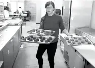  ?? Associated Press ?? Rose Neukam juggles three sheets of cookies on Sept. 15 at Baked in Bloomingto­n, Ind. On Tuesday, the Labor Department released the employment cost index for the third quarter, a measure of wage and benefit growth.