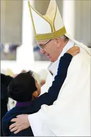  ?? Associated Press photo ?? Pope Francis is embraced by little Lucas Baptista whose medically inexplicab­le healing was the “miracle” needed for the Marto siblings to be declared saints, during a Mass where he canonized Jacinta and Francisco Marto at the Sanctuary of Our Lady of...