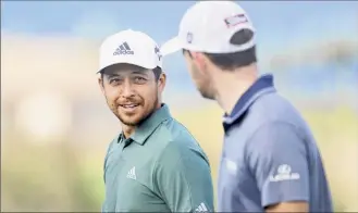  ?? Cliff Hawkins / Getty Images ?? Xander Schauffele and Patrick Cantlay walk from the tenth green during a practice round prior to the Sentry Tournament Of Champions. The event begins Thursday.