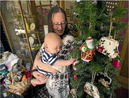  ?? PHOTO: DAVID UNWIN/STUFF ?? Lost Love Found owner Belinda Blair with Jamie Toogood, 5 months, and her decorated ‘‘Pops of Christmas’’ tree from Palmy Unleashed.
