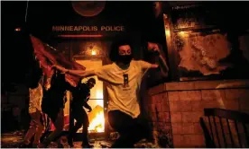  ?? Photograph: Carlos Barría/Reuters ?? Protesters react set fire to the entrance of a police station in Minneapoli­s, Minnesota.