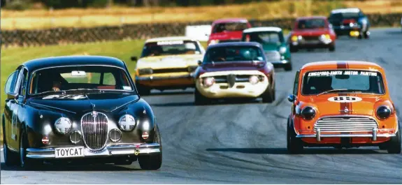  ??  ?? Above: Holding off a challenge at Teretonga Park from some much bigger cars (photo: Euan Cameron) Left: Original builder of the Brink Mini, Murray Cockburn (right) with Howard Kingsfords­mith at the Teretonga Evolution Motorsport Classic Speedfest meeting in February this year
Right: Dennis Chapman in his Fiat X1/9, hard on the heels of the Brink Mini through Castrol at Teretonga Park (photo: Euan Cameron)