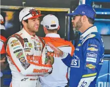  ?? THE ASSOCIATED PRESS ?? Chase Elliott, left, and Jimmie Johnson talk inside the garage area before practice for Sunday’s NASCAR Cup Series race at Phoenix Internatio­nal Raceway on Friday. Both drivers are looking to fill the final spot for the championsh­ip four.