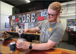  ?? (NWA Democrat-Gazette/David Gottschalk) ?? Shelton Wooley, creative director at Core Brewery and Distillery, pours a 25th State Craft Cocktail inside the Core Brewing Tap Room in Springdale. Check out nwaonline.com/210509Dail­y/ and nwadg.com/photos for a photo gallery.