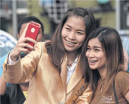  ??  ?? Ratchanok Intanon, left, takes a selfie with a Thai fan.