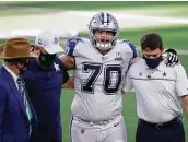  ?? Ron Jenkins / Associated Press ?? Cowboys offensive lineman Zack Martin is assisted off the field by the team’s medical staff Thursday.
