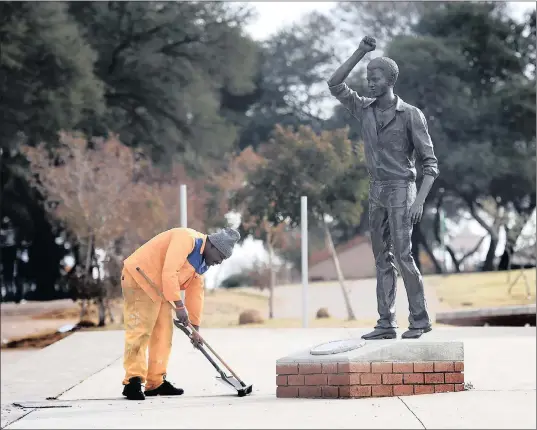  ??  ?? THE FIGHT IS NOW AGAINST DRUG ADDICTION: A worker is seen sweeping near the Tsietsi Mashinini Statue at Memorial Acre, facing the Morris Isaacson High School in Soweto.