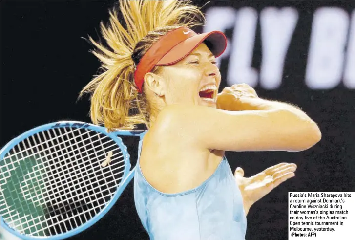  ?? (Photos: AFP) ?? Russia’s Maria Sharapova hits a return against Denmark’s Caroline Wozniacki during their women’s singles match on day five of the Australian Open tennis tournament in Melbourne, yesterday.