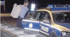  ?? Foto: Daniel Bothe, dpa ?? Ein Polizist sichert bei Roermond in Holland den Kanister, auf dem der flüchtige Autofahrer Benzin nachtankte.