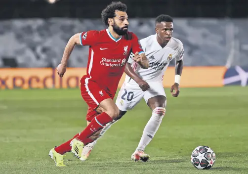  ??  ?? Liverpool striker Mohamed Salah (L) tries to go past Real Madrid’s Vinicius Jr. during the UEFA Champions League quarterfin­al first leg match at the Alfredo Di Stefano stadium, Madrid, Spain, April 6, 2021.