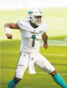  ?? Doug Murray / Associated Press ?? The Dolphins’ Tua Tagovailoa celebrates his first career TD pass, to wide receiver DeVante Parker, against the Rams.