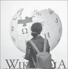  ??  ?? A visitor stands in front of the stand of online encyclopae­dia Wikipedia at the Frankfurt Book Fair on Friday. France is this year’s guest of honour at the world’s largest book fair, where more than 7,000 exhibitors from more than 100 countries are...