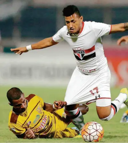  ?? Fernando Llano/AP ?? O atacante Rogério, do São Paulo, é puxado pelo lateral esquerdo Páez, do Trujillano­s, na Venezuela; a partida terminou empatada por 1 a 1 e não favorece nenhuma das equipes em busca da classifica­ção