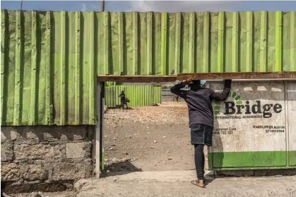  ?? ?? A child waits at the entrance of Bridge Internatio­nal Academies in the Mukuru Kwa Njenga settlement in Nairobi, Kenya. Photograph: Brian Otieno/bryanjaybe­e@gmail.com/PHOTO BY BRIAN OTIENO