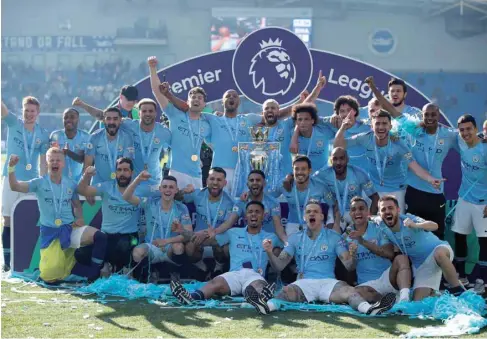  ?? (Reuters) ?? In this May 12, 2019, picture, Manchester City players pose with the trophy as they celebrate winning the Premier League in Brighton, United Kingdom.