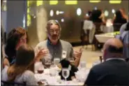  ?? EMILIANO RODRIGUEZ MEGA — THE ASSOCIATED PRESS ?? Michael Nedell, center, eats dinner in the Hall of the Universe at the adult-only sleepover on Friday, June 22, 2018, in New York. Nedell, 53, recalled how he used to be afraid of the 94-foot-long blue whale exhibit that hangs from the ceiling of the Hall of Ocean Life. “When I was younger, that blue whale freaked me out. I’d been scared of (it) until I grew into a teenager,” he said. “Now I get to