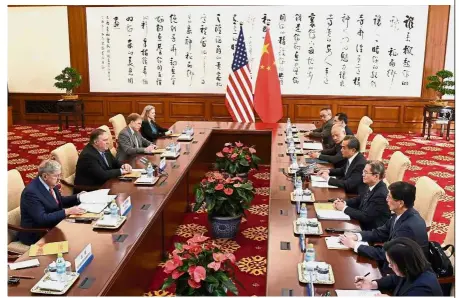  ?? — AFP ?? Meeting of minds: Wang (right row, fourth from top) discussing with Pompeo (left row, third from top) during their meeting at the Diaoyutai State Guesthouse in Beijing.