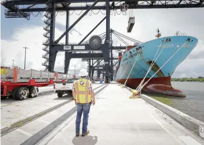  ?? Steve Gonzales / Staff photograph­er ?? Vessel services superinten­dent Cody Young watches the Maersk Kensington ship unload its cargo Wednesday at the port.