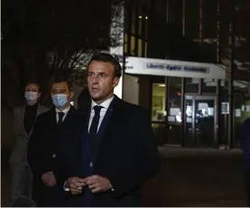  ?? AP ?? ‘STAND ALL TOGETHER’: French President Emmanuel Macron joins other officials to speak outside a school in a Paris suburb. A teacher at the school was beheaded in an ‘Islamist terrorist attack’ after discussing caricature­s of the prophet Muhammad with his class.