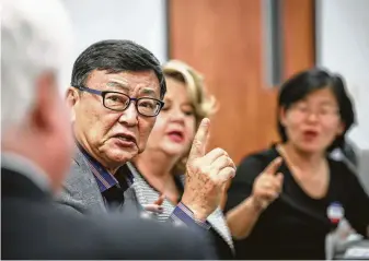  ?? Photos by Jon Shapley / Staff photograph­er ?? Casey Youn, second from left, a member of the Korean-American Voters League, and others speak with Harris County Clerk Stan Stanart, left, to resolve a translator issue.