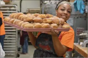  ?? ERIC BONZAR — THE MORNING JOURNAL ?? Tahlia Williams, of Lorain, carries out a fresh tray of paczki from the kitchen of Kiedrowski’s Simply Delicious Bakery, 2267 Cooper Foster Park Road, on Feb. 28. Kiedrowski’s has celebrated Fat Tuesday, with their deep-fried Polish treats, for more...