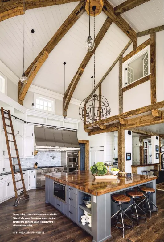  ??  ?? Shiplap ceilings evoke a boathouse aesthetic in this Midwest lake house. The exposed beams echo the dark flooring, providing a stark contrast with the white walls and ceiling.
