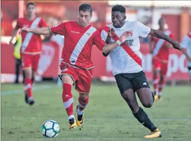  ??  ?? LUCHA. El rayista Embarba y el sevillista Yan Eteki pugnan por un balón durante el partido.