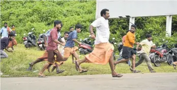  ?? Photo / AP ?? Protesters flee after clashing with police outside the temple.