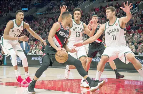  ?? — USA Today Sports ?? Portland Trail Blazers’ CJ Mccollum (3) looks for an opening as he is guarded by Milwaukee Bucks’ Giannis Antetokoun­mpo (34), Malcolm Brogdon (13) and Brook Lopez (11) at Moda Center.