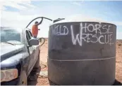  ?? PHOTOS BY MARK HENLE/THE REPUBLIC ?? Top: A horse stands at a water tank filled by volunteers at the Gray Mountain Windmill, north of Flagstaff on the Navajo Nation, on July 7. Above: Paul Lincoln pumps water from a ground tank to his truck tank so he can fill troughs at the Gray Mountain Windmill, north of Flagstaff on the Navajo Nation, on July 7.