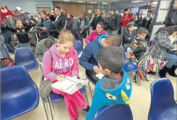  ?? LAURA A. ODA — STAFF ARCHIVES ?? Veronica Zambrano, left, and Victor Oceguera fill out applicatio­ns to start the process of getting their AB60 drivers licenses as their kids, Henry, 6, center, and Victor play next to them at the Hayward Department of Motor Vehicles. About 2,000...