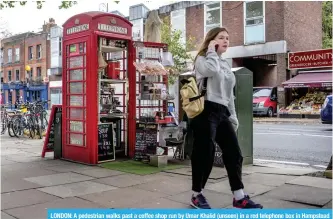  ??  ?? LONDON: A pedestrian walks past a coffee shop run by Umar Khalid (unseen) in a red telephone box in Hampstead Heath, north London.