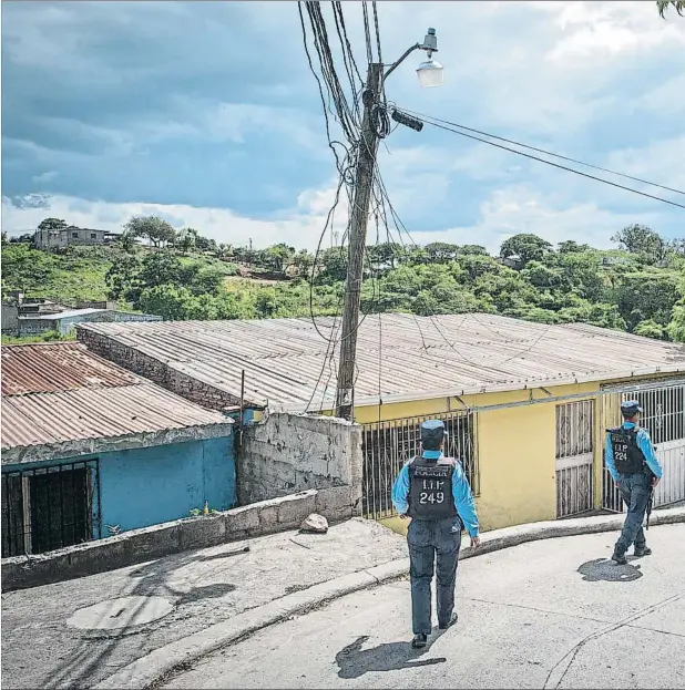  ??  ?? La policía hondureña patrulland­o una calle de Tegucigalp­a, la capital de uno de los países con mayor tasa criminal del mundo