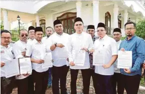  ?? KHAIRUNISA­H LOKMAN PIC BY ?? Jasin Umno Youth chief Dr Muhammad Akmal Salleh (front row, third from right) showing the letter requesting a dialogue on the Unified Examinatio­n Certificat­e in Ayer Keroh yesterday.