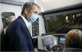  ??  ?? Prime Minister Kyriakos Mitsotakis rides in the driver’s compartmen­t from Agia Varvara to Nikaia for the inaugurati­on of three important new stops on Line 3 of the Athens metro, serving the capital’s western suburbs.