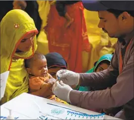  ?? Rizwan Tabassum AFP/Getty Images ?? A PARAMEDIC takes a blood sample from a baby for an HIV test in Ratodero, Pakistan. More than 750 new infections have been reported in Larkana district.