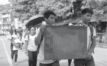  ?? Photo by Alpine Killa ?? YOUTH VOICE. Two students from Xijen College of Mountain Province Inc. holds a slogan as a support in the campaign against smoking in the capital town Bontoc.