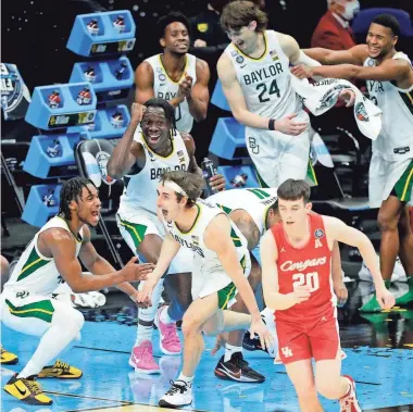  ?? ROBERT SCHEER/INDYSTAR ?? The Baylor bench celebrates after guard Mark Paterson made a basket against Houston during the semifinals of the men’s Final Four on Saturday at Lucas Oil Stadium in Indianapol­is.