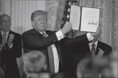  ?? The Associated Press ?? SPACE FORCE: President Donald Trump shows off a “Space Policy Directive” after signing it during a meeting of the National Space Council in the East Room of the White House, Monday in Washington.