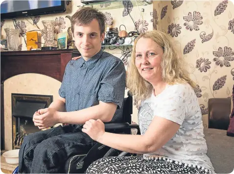  ??  ?? Mark and mum Margaret must raise £60,000 to fund the robotic trousers which would change his life.