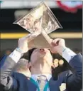  ?? KathyWille­ns Associated Press ?? JUSTIN ZAYAT, son of American Pharoah owner Ahmed Zayat, kisses the Triple Crown trophy.