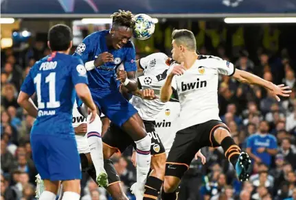  ?? — Reuters ?? Off target: Chelsea’s Tammy Abraham (centre) heading the ball during the Champions League Group H match against Valencia at Stamford Bridge on Tuesday.