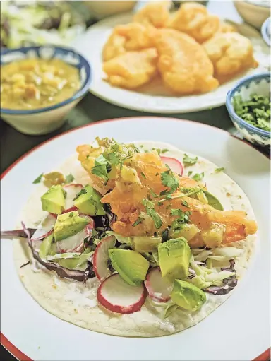  ?? Gretchen McKay / TNS ?? Beer-battered shrimp are stuffed into a flour tortilla with shredded cabbage, lime crema, avocado and salsa verde for a Lenten taco.