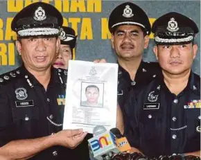  ?? BY EDMUND SAMUNTING PIC ?? Kota Kinabalu district police chief Assistant Commission­er Habibi Majinji (left) with a mugshot of Sisal Benigno, a murder suspect.