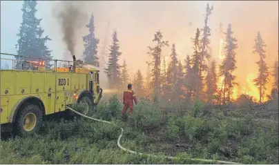  ?? CP PHOTO ?? A fire crew battles a blaze in the La Ronge area of northern Saskatchew­an.