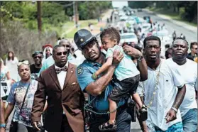  ?? SCOTT OLSON/GETTY ?? Marchers in St. Louis mark the anniversar­y of the death of Michael Brown, an AfricanAme­rican who was fatally shot by a Ferguson, Mo., police officer in 2014.